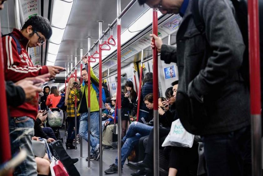 Commuters using their phones as they ride on an MTR underground train in Hong Kong, on Jan 29, 2019. PHOTO: AFP