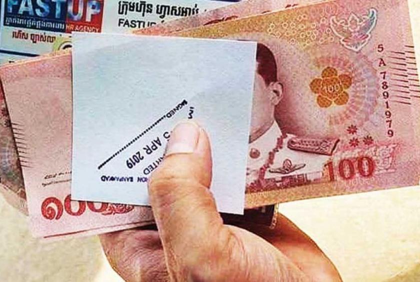 A migrant worker holding Thai baht. Cambodian migrant workers crossing the border from Thailand for the Khmer New Year holiday claimed they were forced to pay 40,000 riel ($10) to get priority in filling out application forms. Photo supplied to Phnom Penh Post