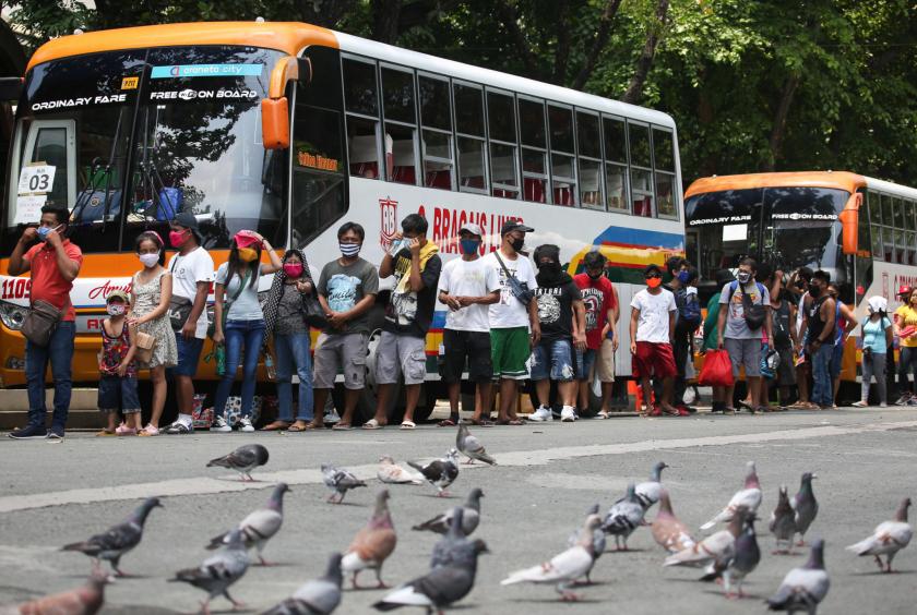 WHERE THERE’S WORK, HOPEFULLY The government’s “Balik Probinsya” program seeks to help Metro Manila residents who were rendered jobless by the economic slowdown caused by the coronavirus pandemic and who now wish to start life anew in their home provinces. Some of the beneficiaries line up outside Baclaran church in Parañaque City on Friday to wait for the bus taking them to the Bicol region. —LYN RILLON