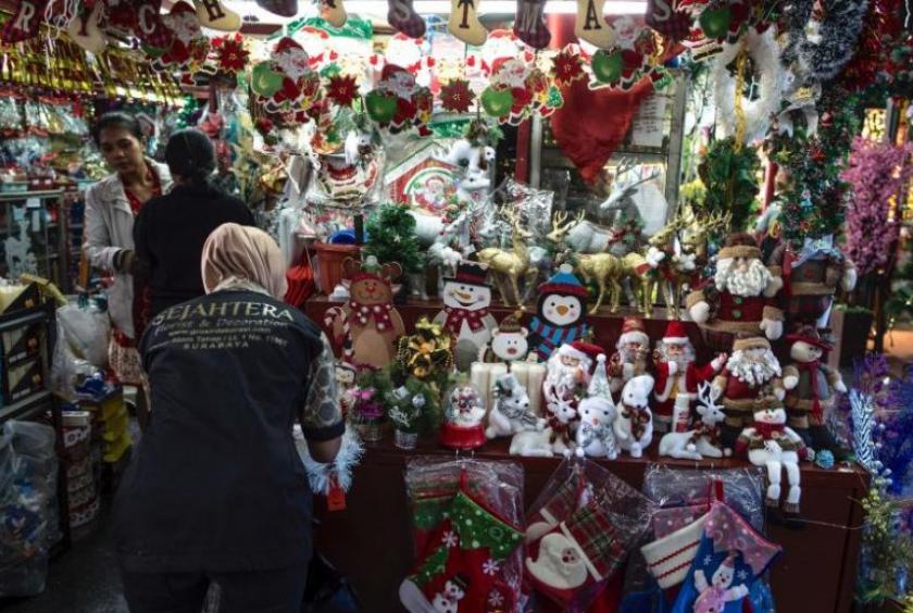 An Indonesian Muslim woman serves her customers at a Christmas decoration shop in Surabaya, Indonesia on Dec 20, 2019. In some places, Christmas celebrations are restricted.PHOTO: AFP