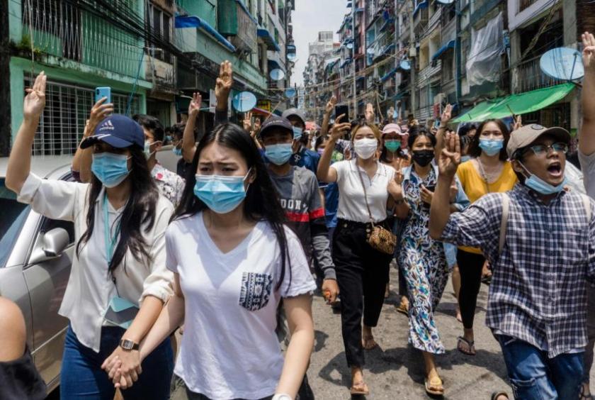Protesters make the three-finger salute during a demonstration in Yangon on April 27, 2021.PHOTO: AFP