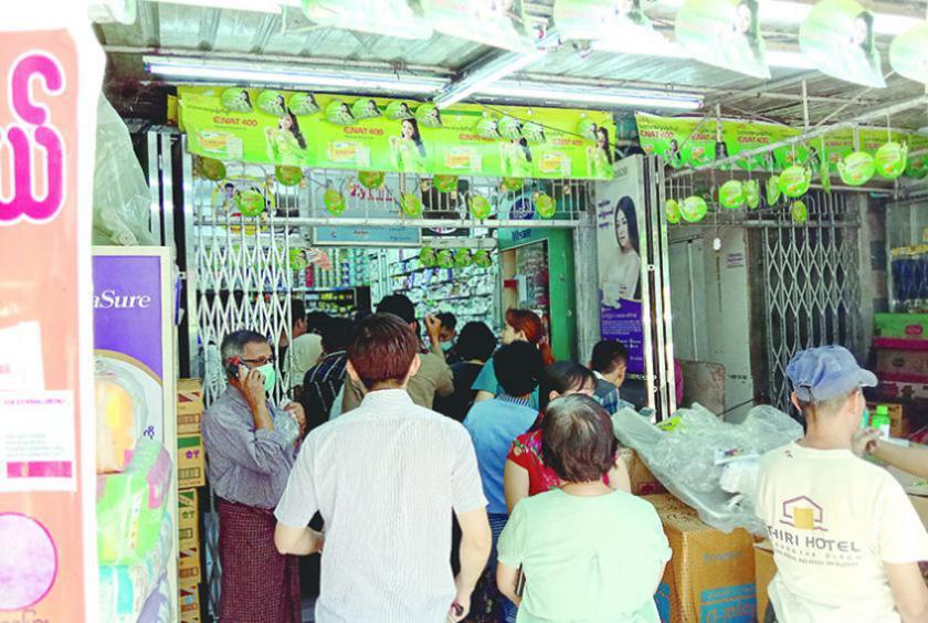 Shoppers queuing to buy medicines at a pharmacy in Tamway Township