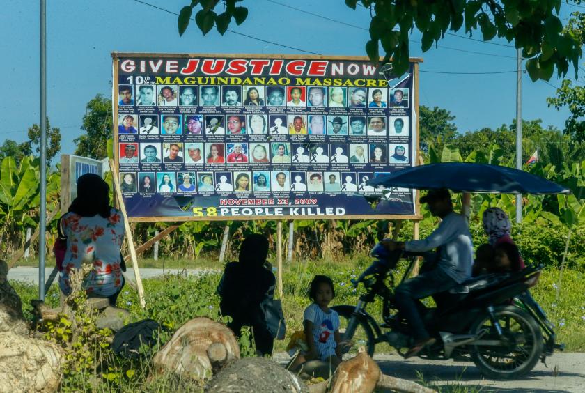 JUSTICE IS COMING A billboard with pictures of the 58 victims of the Nov. 23, 2009, Maguindanao massacre stands on a side of the road to Barangay Salma Ampatuan in Maguindanao province, where they were stopped by gunmen that included members of the Ampatuan political clan, hauled up a rise above the road, and mowed down. —JEOFFREY MAITEM