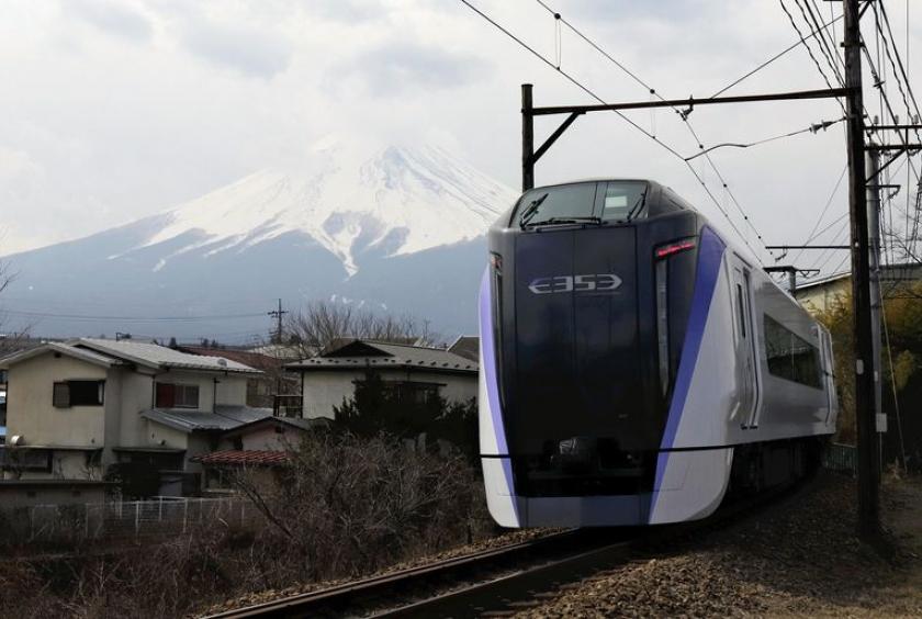 The Fuji Kaiyu limited express train runs in Fujiyoshida, Yamanashi Prefecture, on Saturday morning, with Mt. Fuji in the background.