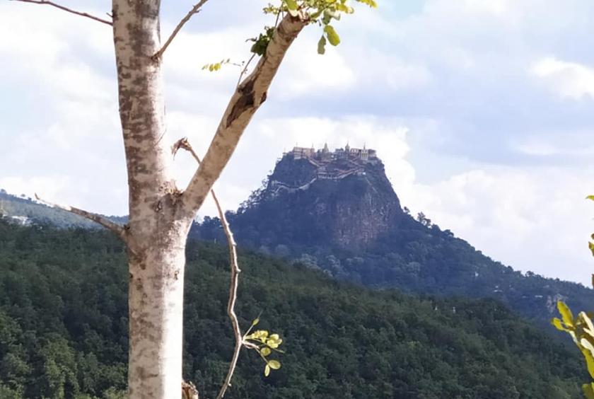 The photo shows a distant view of Papa Taungkalat. 