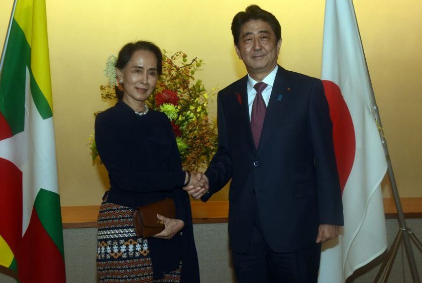 Aung San Suu Kyi shakes hands with Japanese PM Shinzo Abe in Tokyo, Japan. (Photo-AFP)