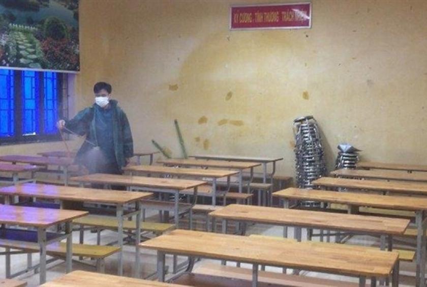 A health official spray disinfectant in a classroom in northern Vĩnh Phúc Province. — Photo courtesy of the provincial Department of Education and Training