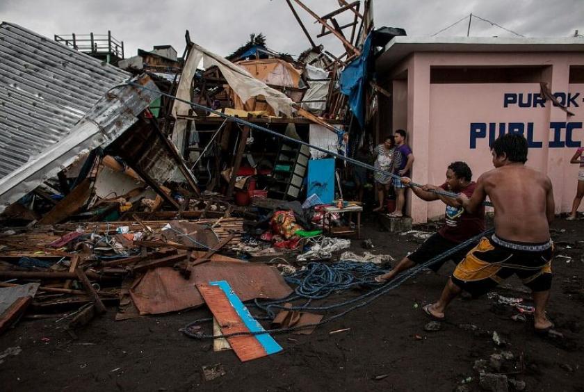 Villagers working among damaged houses in the aftermath of Typhoon Kammuri in Legazpi city, the Philippines' Albay province, yesterday. The typhoon made landfall late on Monday and forced the closure of the main airport in Manila for most of yesterday. There was no electricity in 10 areas in Luzon, as strong winds toppled power lines. PHOTO: EPA-EFE