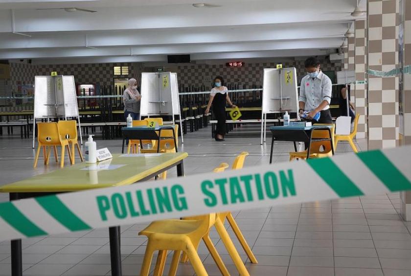 At Chung Cheng High School in Goodman Road yesterday, public servants set up the polling station, putting in place safe-distanced polling booths, temperaturetaking points, sanitising products and floor markings for spaced queues to ensure the safety of voters.PHOTO: LIANHE ZAOBAO