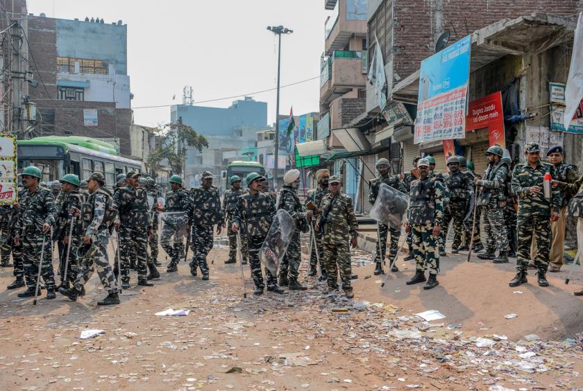 Security personnel stand guard near burnt-out and damaged shops following clashes between people supporting and opposing a contentious amendment to India's citizenship law, in New Delhi on February 26, 2020. Riot police patrolled the streets of India's capital on February 26 following battles between Hindus and Muslims that claimed at least 20 lives, with fears of more violent clashes. (Sajjad HUSSAIN / AFP)