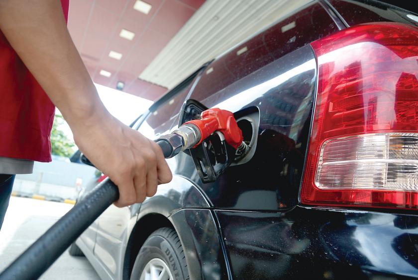 An attendant fills a car at a local private filling station in Yangon. 