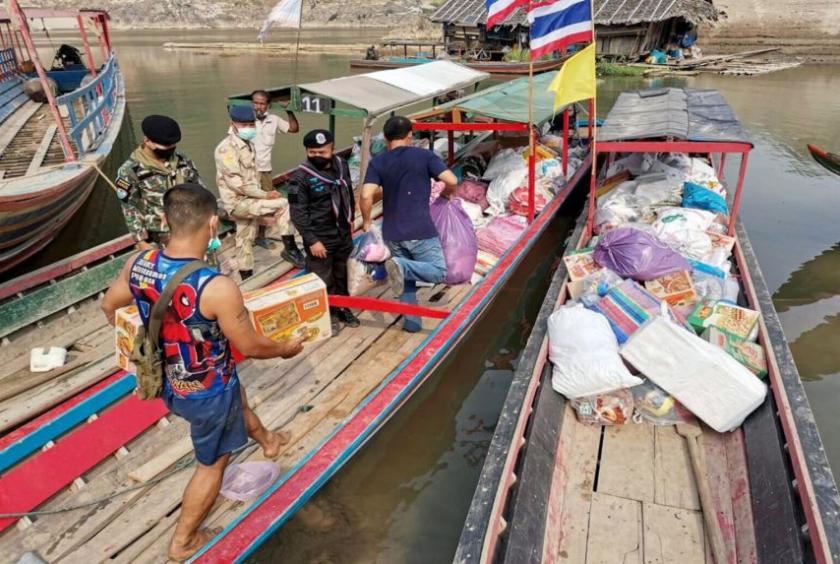 Donated rations for Myanmar refugees being loaded onto a boat in a Thai village near the Myanmar border last week. The writer says the Thai foreign policy establishment needs to be more assertive in persuading the military to allow Myanmar refugees into the country.PHOTO: EPA-EFE