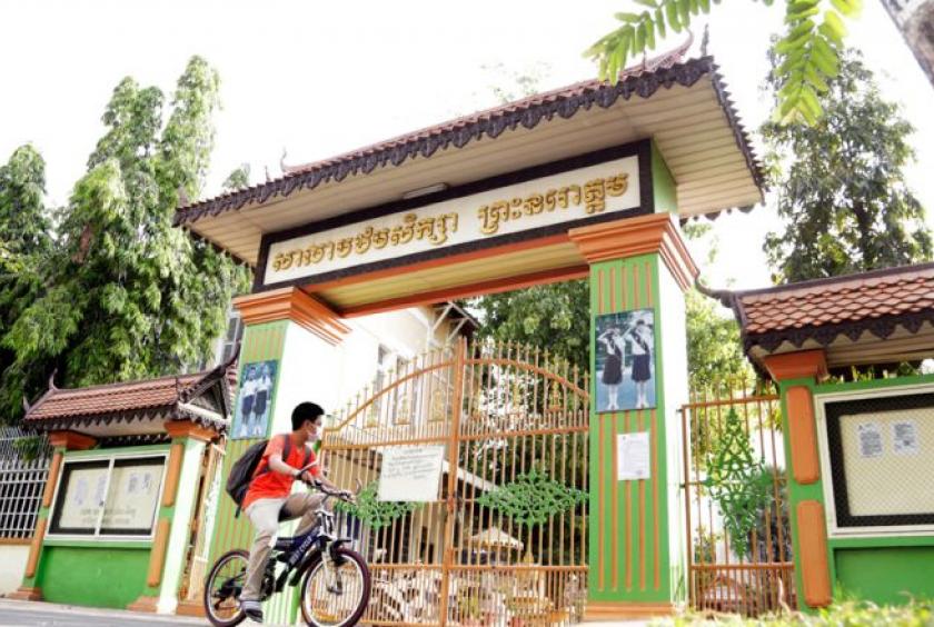 A boy rides past Preah Norodom primary school in Phnom Penh. The government has ordered schools and kindergartens throughout the Kingdom to close as part of its measures to contain the Covid-19 outbreak. Heng Chivoan