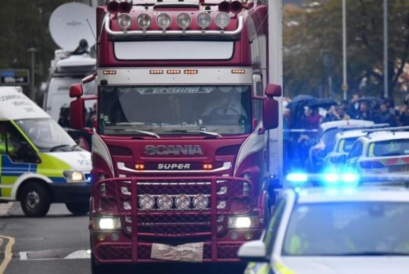 Police officers escort the lorry in which 39 dead bodies were discovered. — AFP Photo