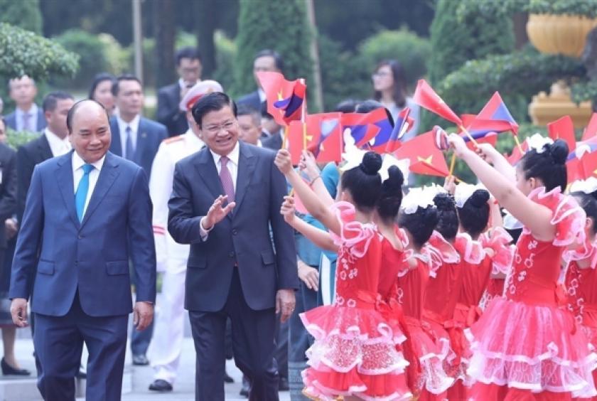 Prime Minister Nguyễn Xuân Phúc and children in Hà Nội welcome Lao Prime Minister Thongloun Sisoulith. The two PMs held talks after the welcome ceremony. — VNA/VNS Photo: Thống Nhất