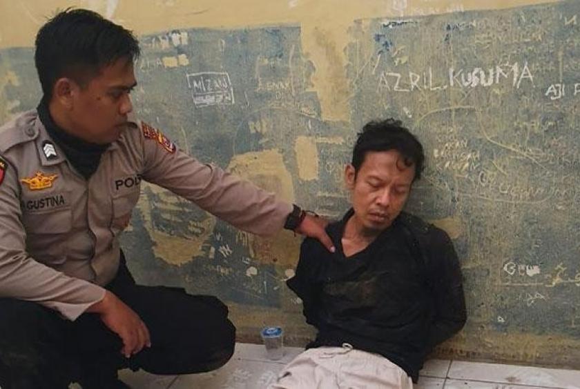 A police officer holds Syahrial Alamsyah at Menes town square in Pandeglang, Banten after Syahrial allegedly attacked Coordinating Political, Legal and Security Affairs Minister Wiranto on Thursday. (Tempo.co/Istimewa)