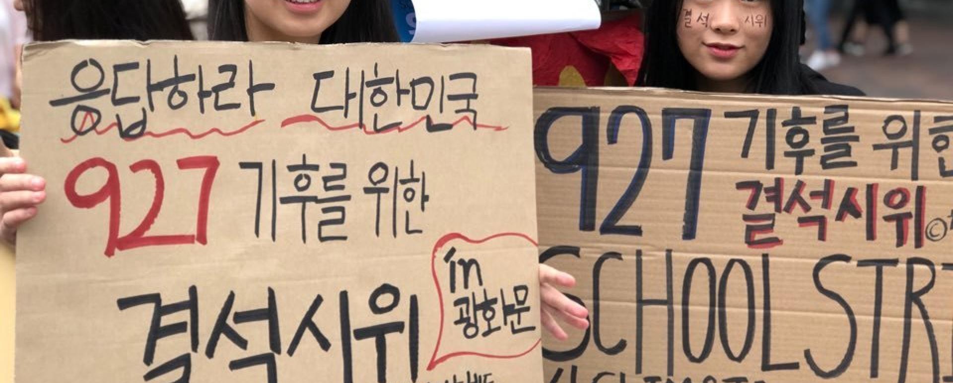 Kim Do-hyeon, a 15-year-old student, holds a placard reading "Answer, Korea. School strike for climate on Sept. 27" with a fellow campaigner. (Ock Hyun-ju/The Korea Herald)