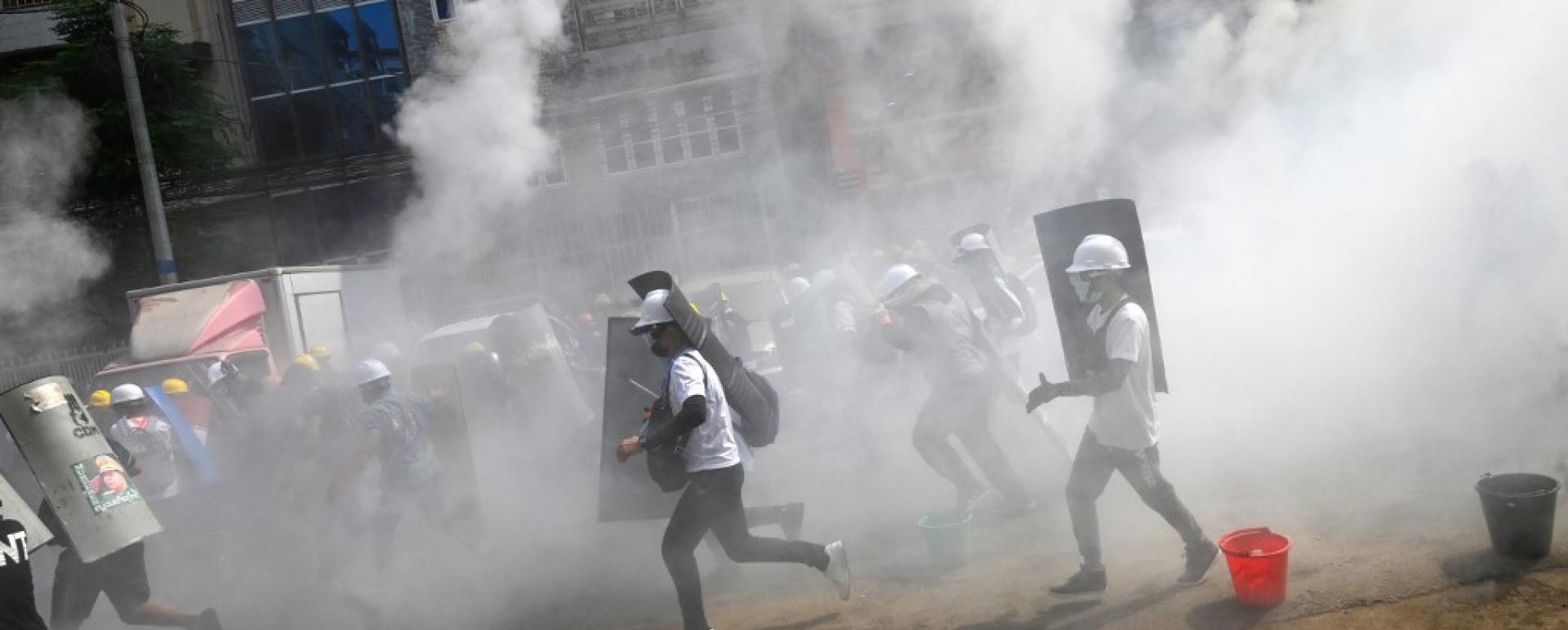 Protesters hold homemade shields as they run during a demonstration against the military coup in Yangon on March 3, 2021. (Agence France Presse/STR)