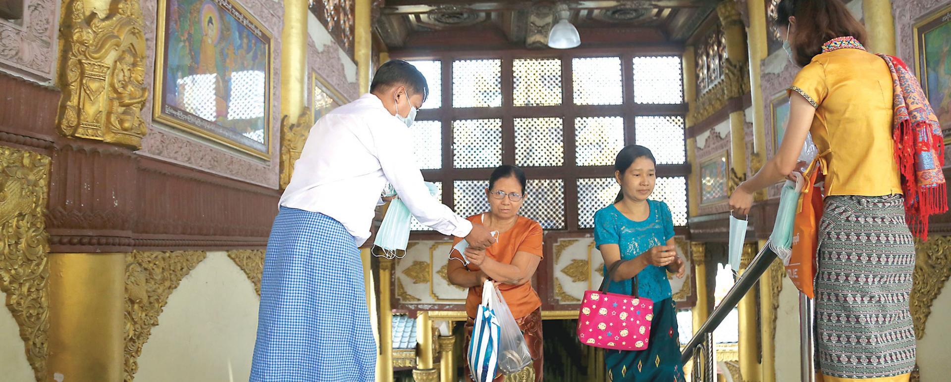 People distribute face masks to pilgrims in Shwedagon Pagoda (Photo-Kyi Naing)