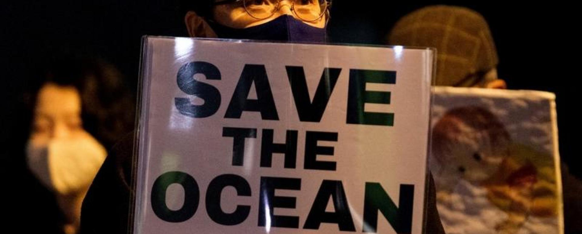 A protestor holds a slogan during a rally against the Japanese government's decision to release treated water from the stricken Fukushima Daiichi nuclear plant into the sea, outside of the prime minister's office in Tokyo on April 13, 2021. (YUKI IWAMURA / AFP)