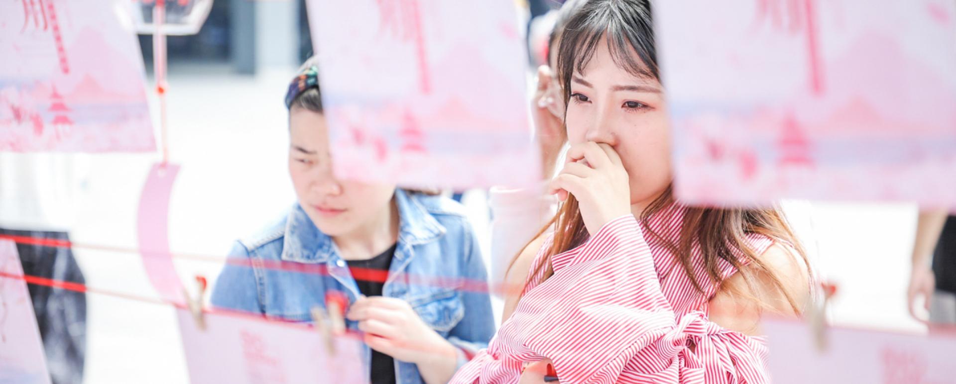 A girl reads a poster at a matchmaking event held by Alibaba Group at its headquarters in Hangzhou, Zhejiang province. There are more than 240 million singles in China, which has spawned a booming singles economy. [Niu Jing/for China Daily]