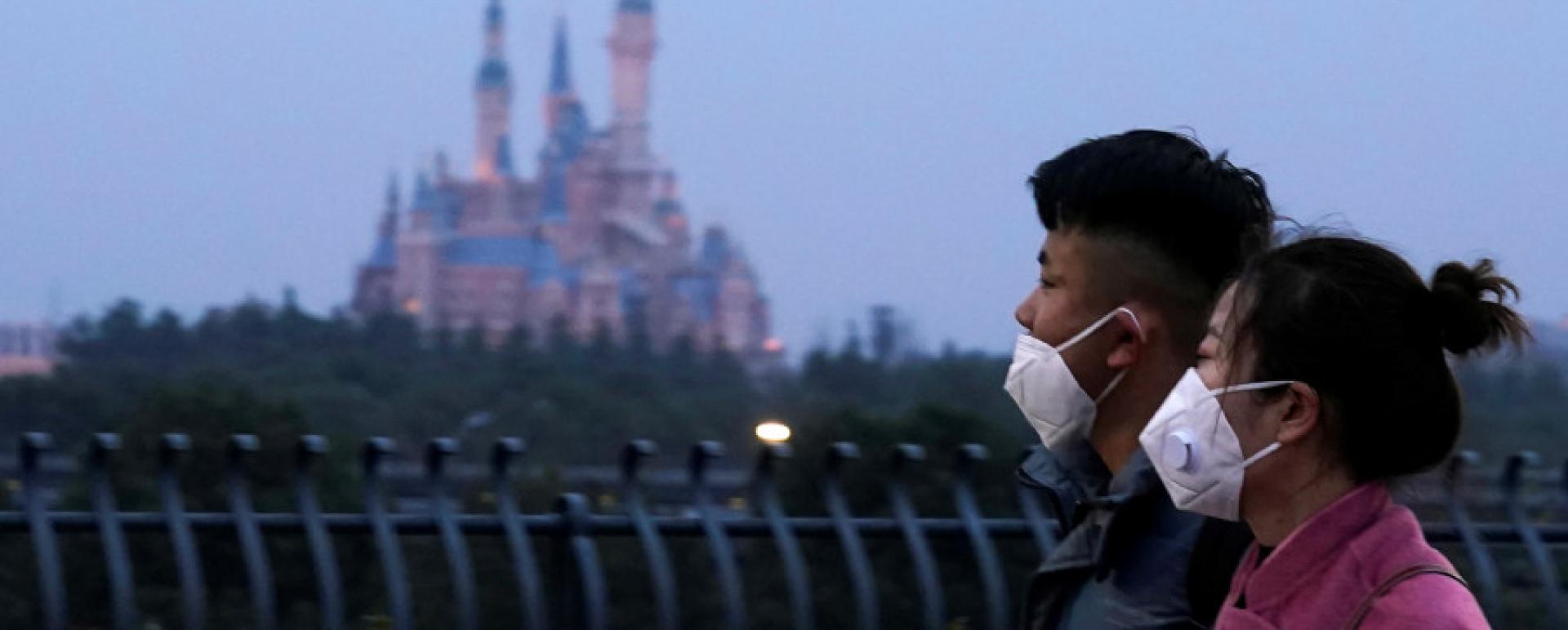  Visitors wearing masks walk past Shanghai Disney Resort, China, on Friday. The resort was closed during the Chinese Lunar New Year holiday on Saturday following the outbreak of a new coronavirus. Reuters