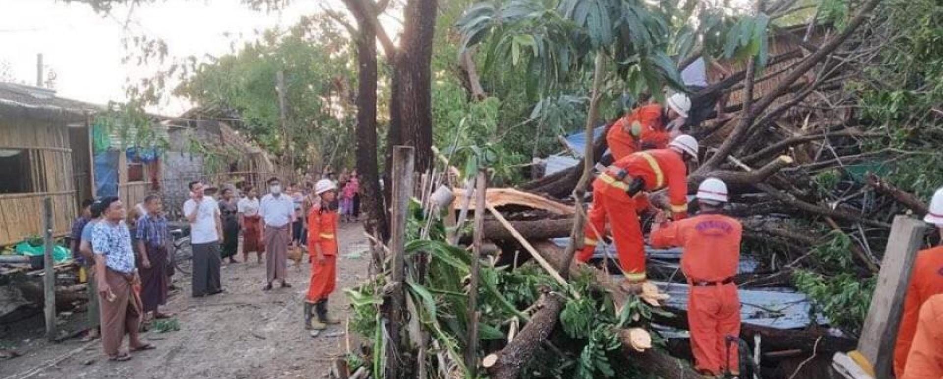 Firefighters clear away the debris from the strong wind